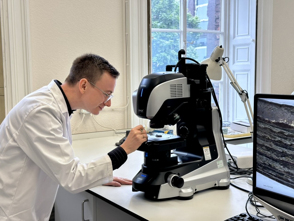 Jordan using microscope in laboratory